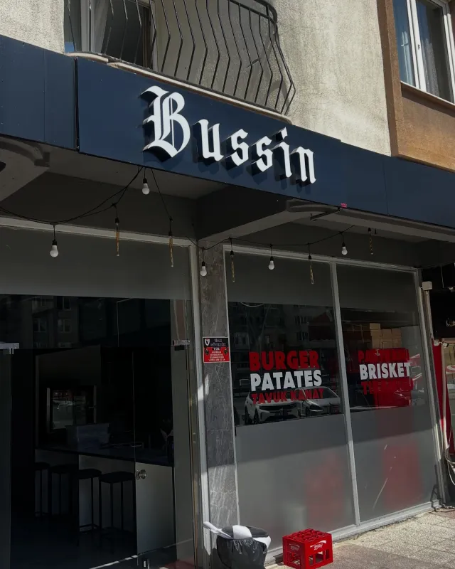 Bussin restoranının lacivert cephe panosu üzerinde beyaz kutu harf tabela ve vitrin folyoları